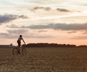 man cycling near wind mill