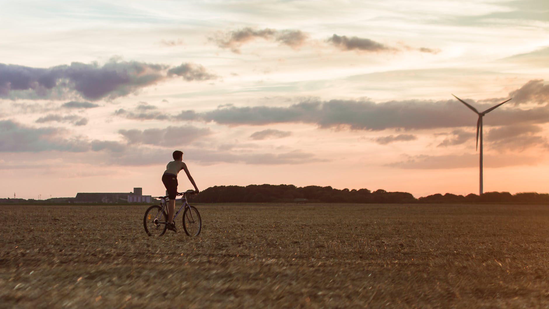 man cycling near wind mill